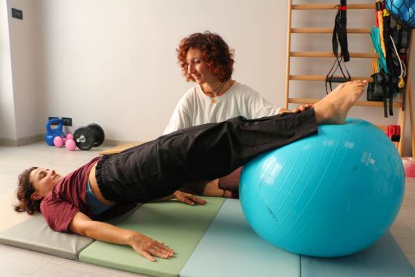 Giulia Cantaluppi segue un esercizio terapeutico con la palla durante una seduta di fisioterapia